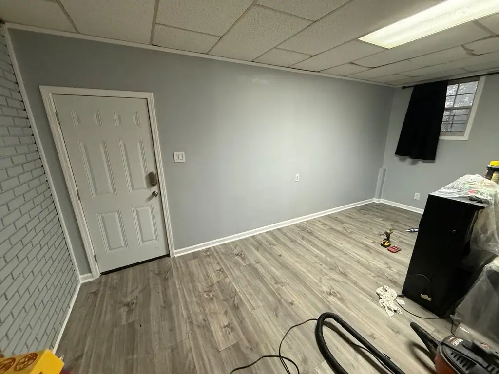 Finished basement room with new flooring and a fresh door