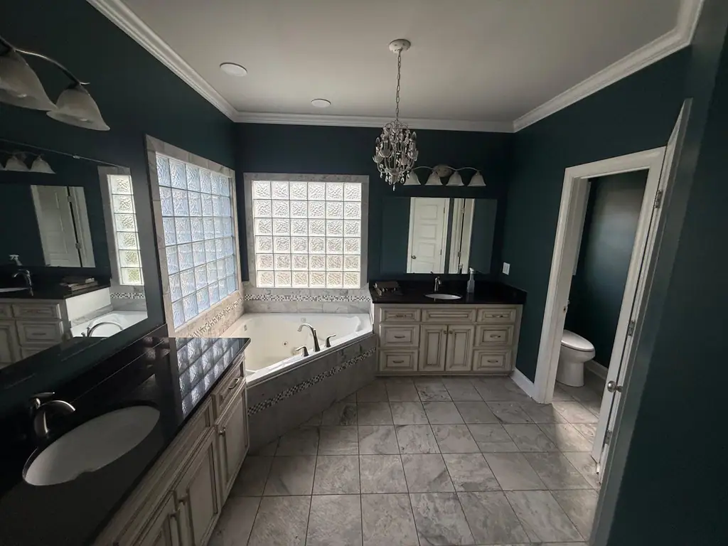 Finished bathroom with tile floor, jetted tub and dark green walls