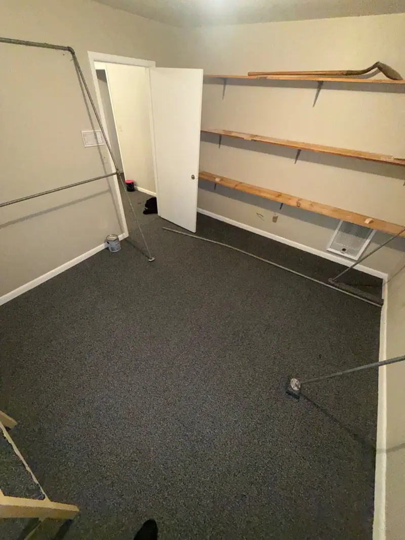 The same closet rebuilt: new grey carpet, clean walls and the shelves back up