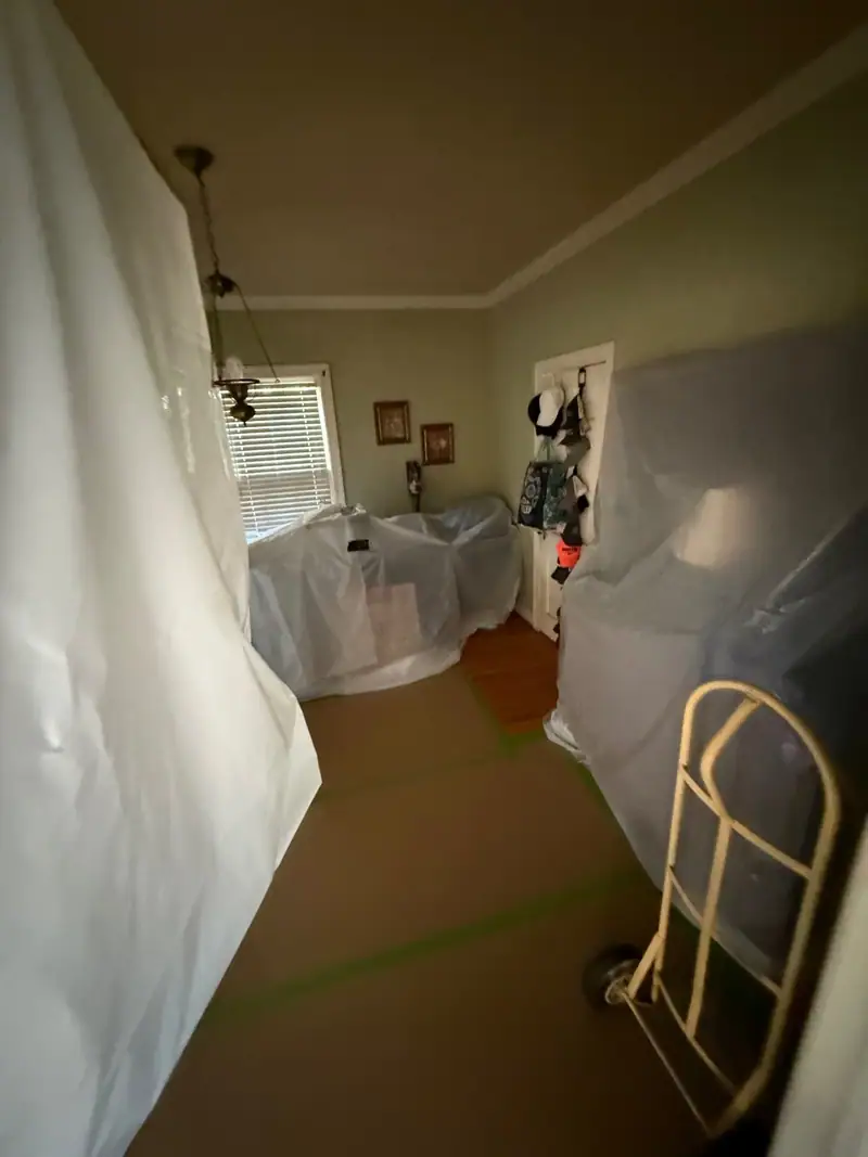 Room sealed in plastic sheeting with furniture covered