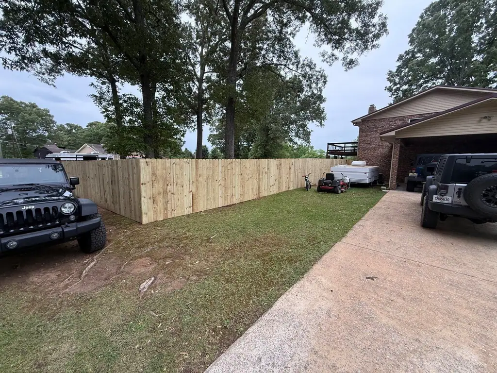 New wood privacy fence along a yard and driveway