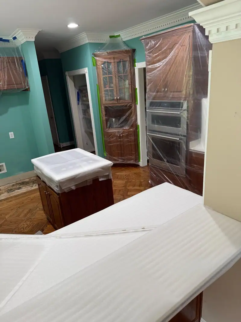 Kitchen cabinets and island wrapped in plastic to protect them during work