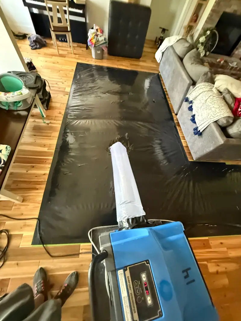 Hose run from a drying unit to floor mats on a hardwood floor