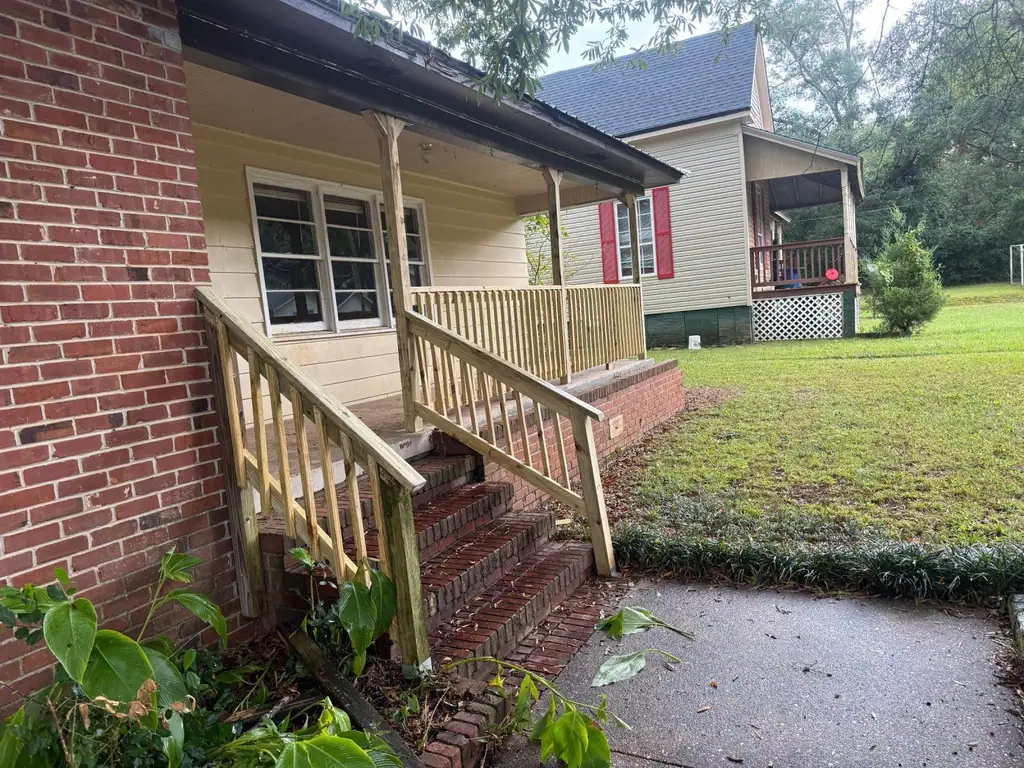 New wooden porch steps and railings on a brick house