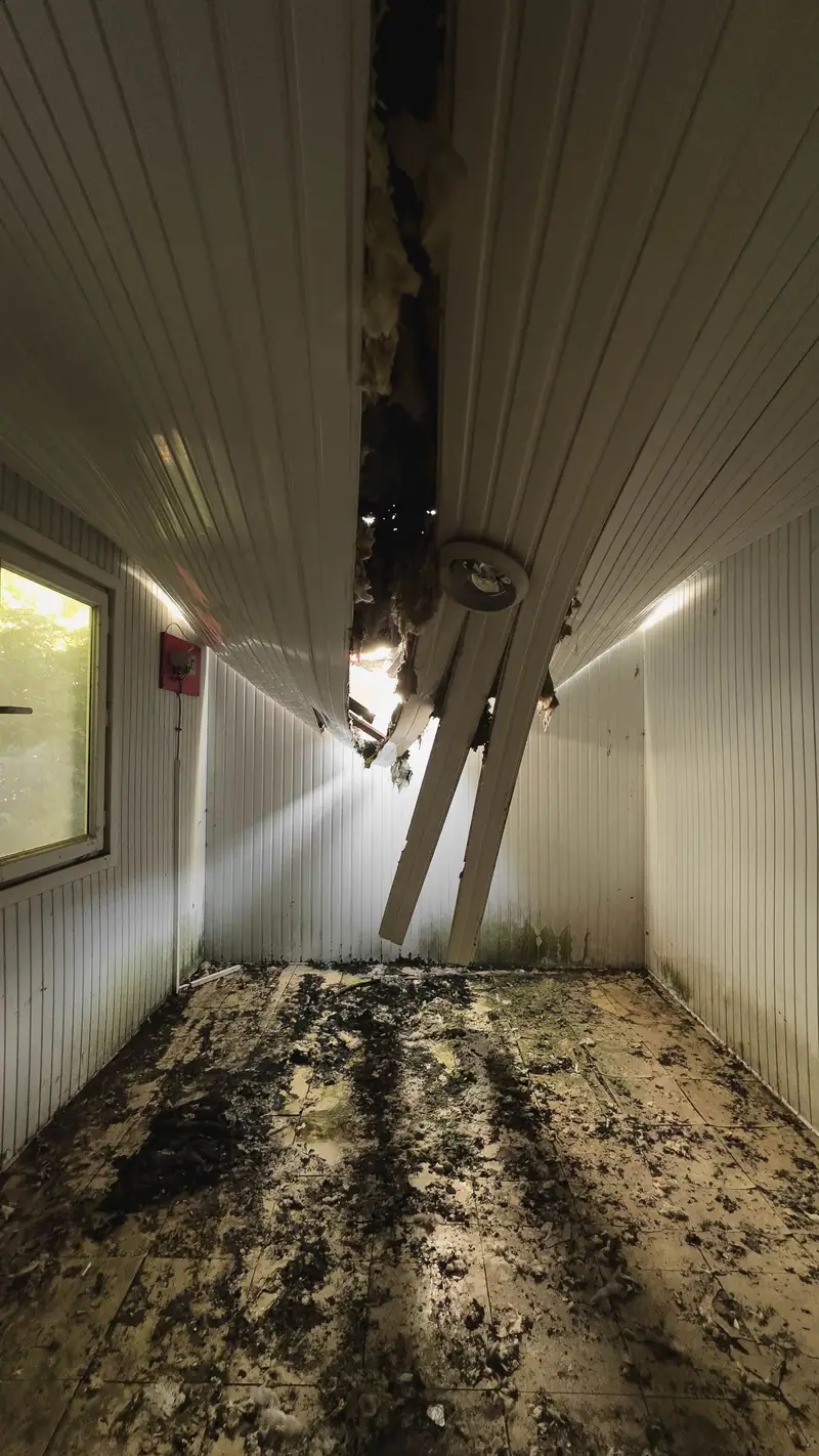 Smoke-blackened hallway with the ceiling burned through